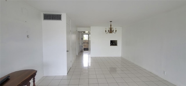 unfurnished dining area with a chandelier, light tile patterned floors, and visible vents