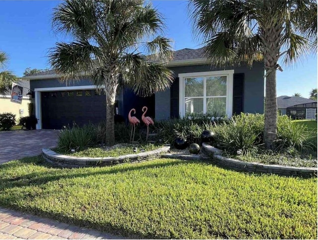 view of front facade featuring a front lawn, decorative driveway, an attached garage, and stucco siding