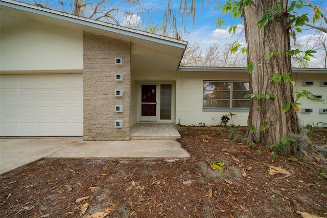 view of exterior entry featuring a garage and concrete block siding