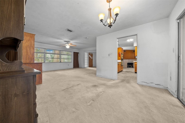 living room featuring light colored carpet, visible vents, and ceiling fan with notable chandelier