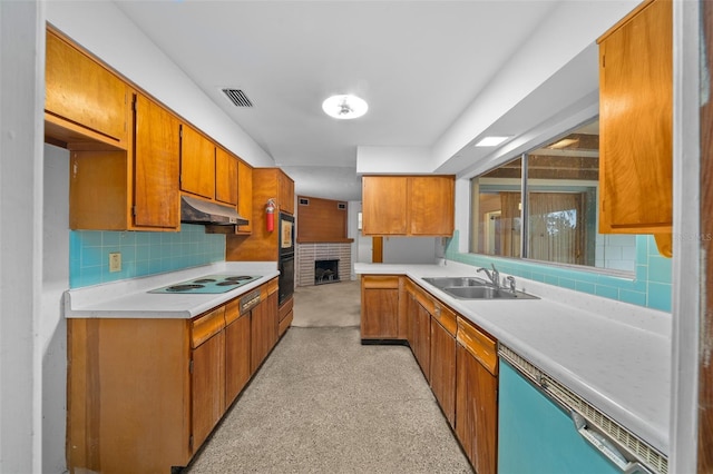 kitchen with visible vents, under cabinet range hood, light countertops, black appliances, and a sink