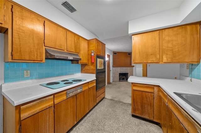 kitchen featuring visible vents, electric cooktop, light countertops, and under cabinet range hood