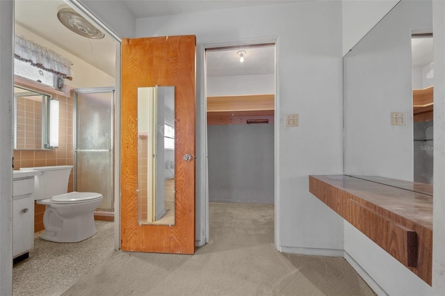 bathroom featuring a shower with shower door and toilet