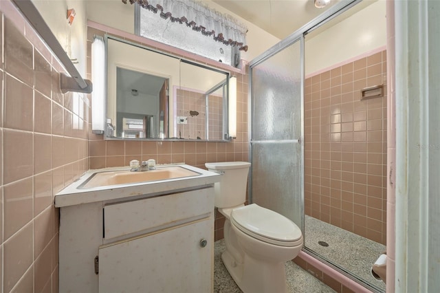 full bathroom featuring tile walls, tasteful backsplash, toilet, a shower stall, and vanity