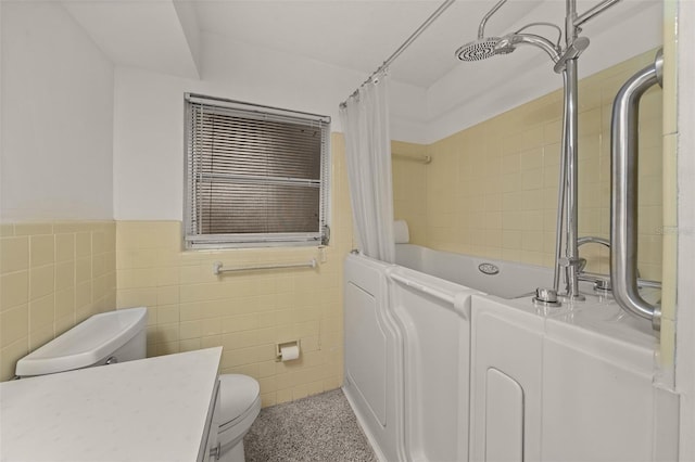 bathroom featuring toilet, a wainscoted wall, shower / tub combo, vanity, and tile walls