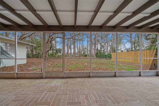 unfurnished sunroom with beam ceiling and a wealth of natural light