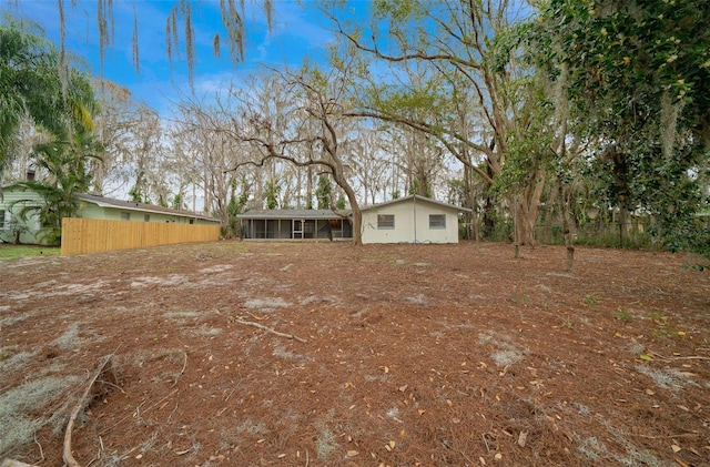 view of yard featuring a sunroom and fence