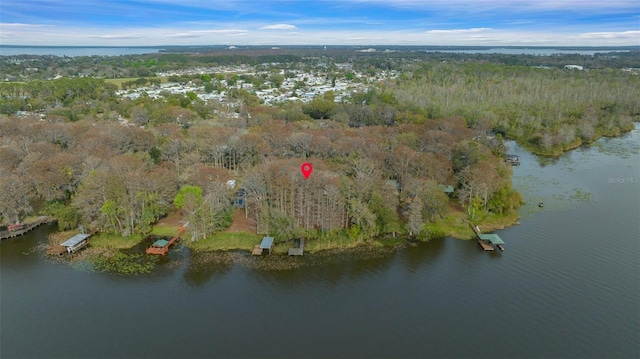 drone / aerial view with a forest view and a water view