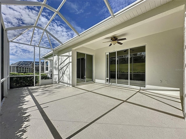 view of patio featuring glass enclosure and a ceiling fan