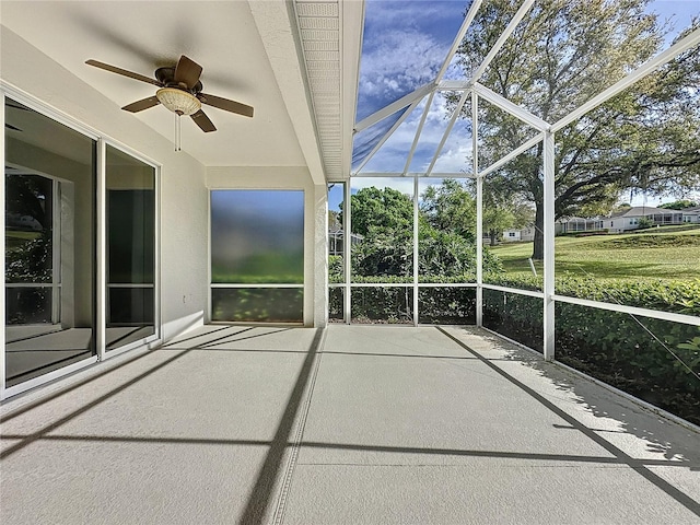 unfurnished sunroom featuring a ceiling fan