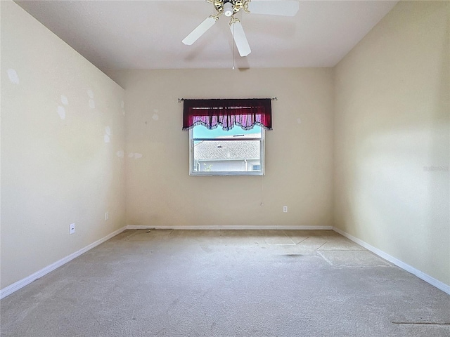 carpeted empty room with ceiling fan and baseboards