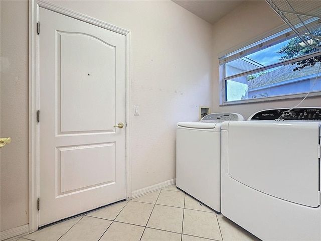 clothes washing area featuring laundry area, light tile patterned floors, baseboards, and independent washer and dryer