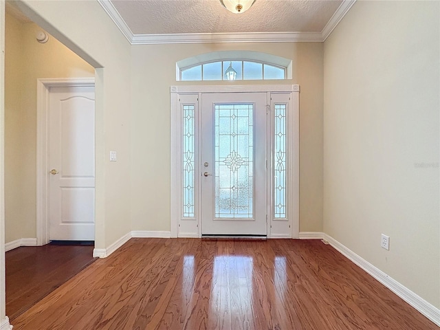 foyer with plenty of natural light, ornamental molding, and wood finished floors