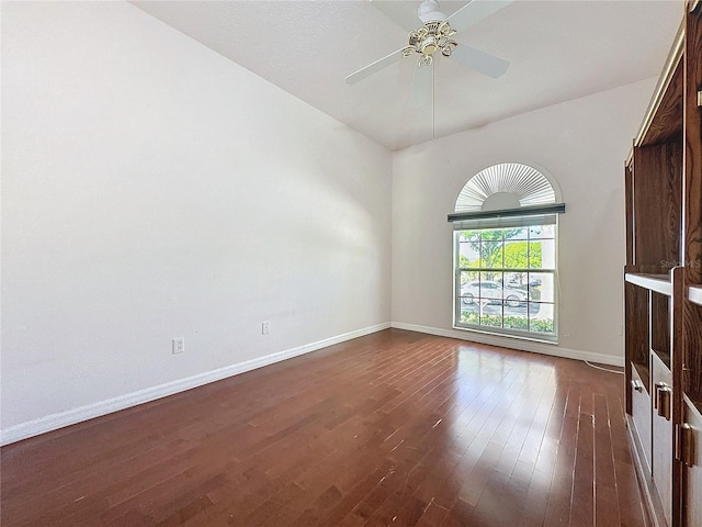 spare room featuring ceiling fan, baseboards, and dark wood finished floors