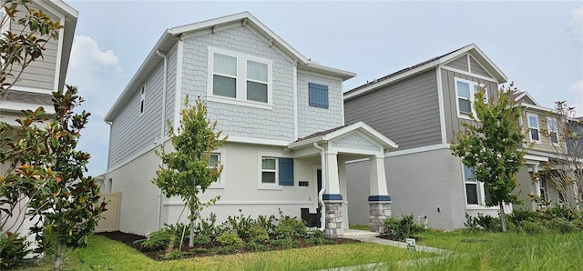 craftsman-style home with a front yard and stucco siding