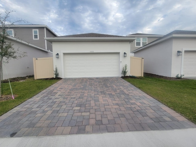 1723 Happiness Row, Kissimmee, FL 34744 - view of front of home with an attached garage, fence, decorative driveway, stucco siding, and a front yard