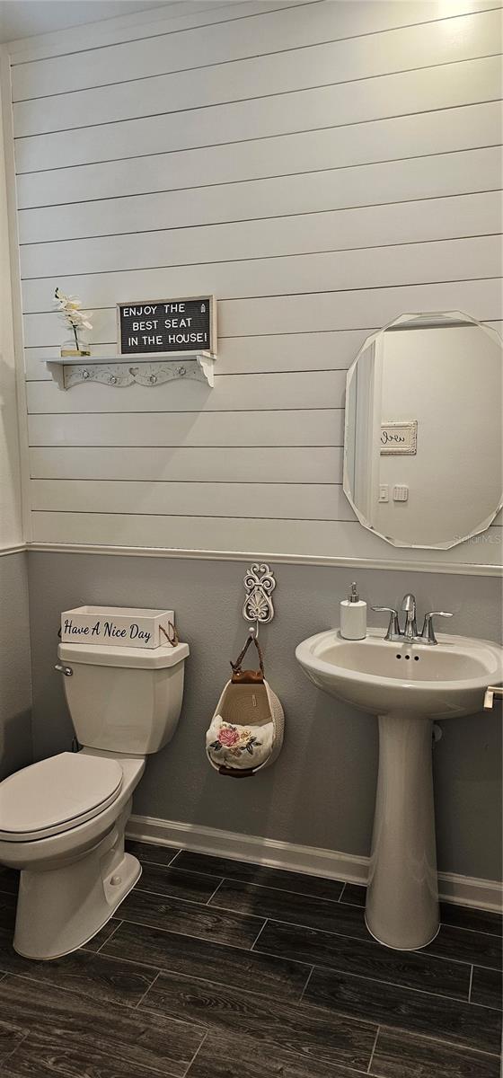 1723 Happiness Row, Kissimmee, FL 34744 - half bathroom featuring wood finished floors, toilet, and baseboards