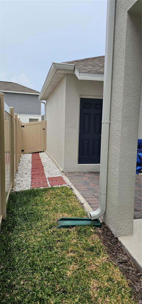 1723 Happiness Row, Kissimmee, FL 34744 - doorway to property featuring a gate, roof with shingles, fence, and stucco siding