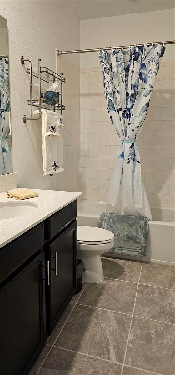 1723 Happiness Row, Kissimmee, FL 34744 - full bath featuring toilet, vanity, and shower / bathtub combination with curtain