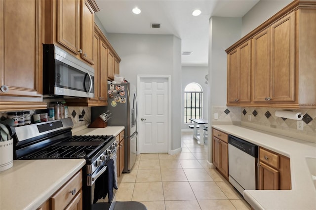 kitchen with light tile patterned floors, visible vents, light countertops, appliances with stainless steel finishes, and decorative backsplash