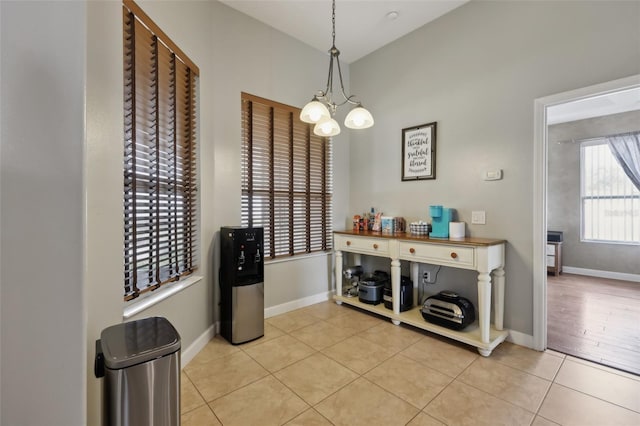 wine cellar featuring a notable chandelier, baseboards, and light tile patterned floors