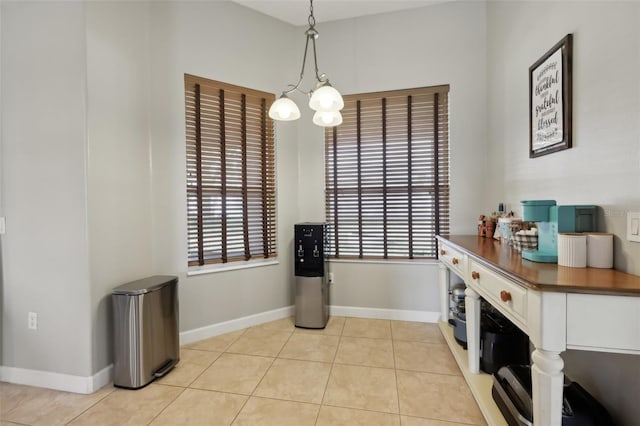 dining space with light tile patterned flooring, plenty of natural light, and baseboards