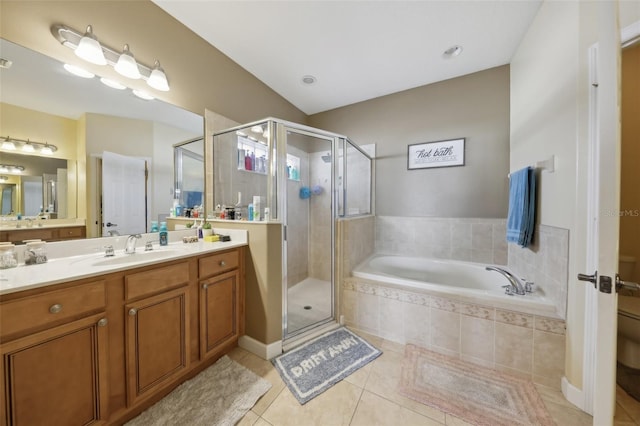 bathroom featuring a stall shower, a garden tub, vanity, and tile patterned floors