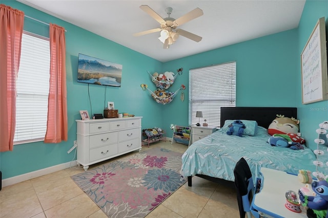 tiled bedroom with ceiling fan and baseboards