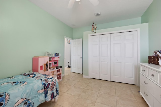 bedroom featuring light tile patterned floors, visible vents, baseboards, ceiling fan, and a closet