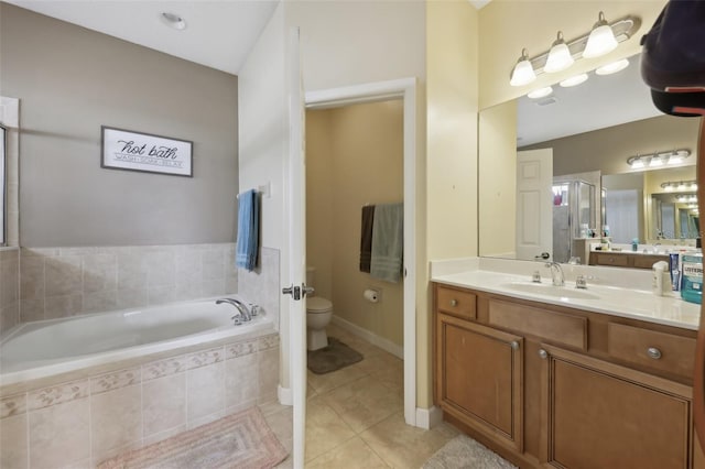 bathroom with a garden tub, toilet, vanity, a shower stall, and tile patterned floors