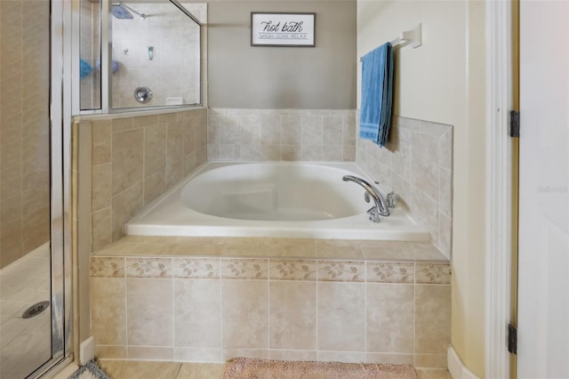 bathroom featuring a stall shower and a bath