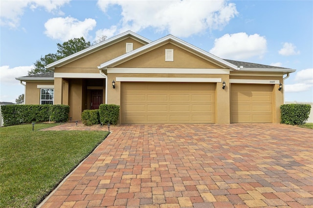 ranch-style home featuring a front yard, decorative driveway, a garage, and stucco siding