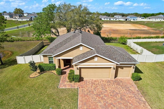 view of front of home with decorative driveway, a garage, a fenced backyard, and stucco siding