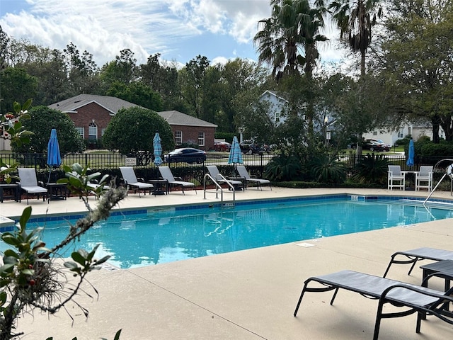 pool with a patio area and fence