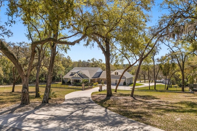 view of community featuring a lawn and fence
