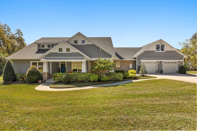 craftsman-style house featuring a porch, a front yard, driveway, and roof with shingles