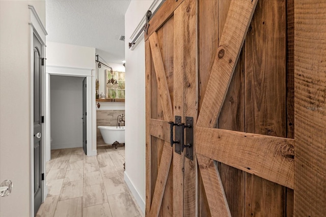 full bathroom with a soaking tub, visible vents, and a textured ceiling