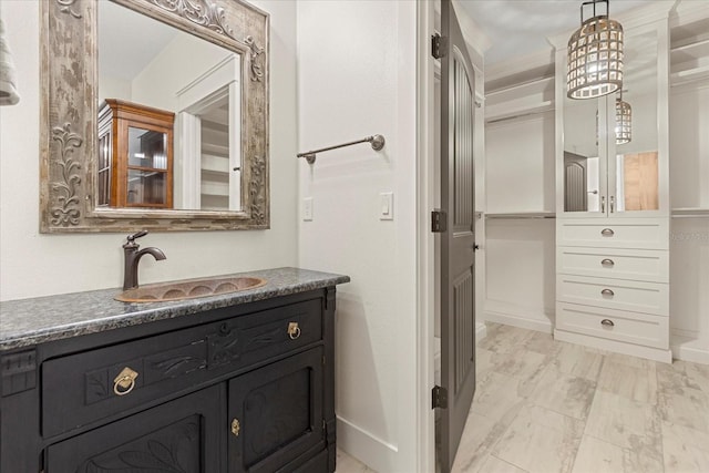 bathroom featuring marble finish floor, baseboards, and vanity