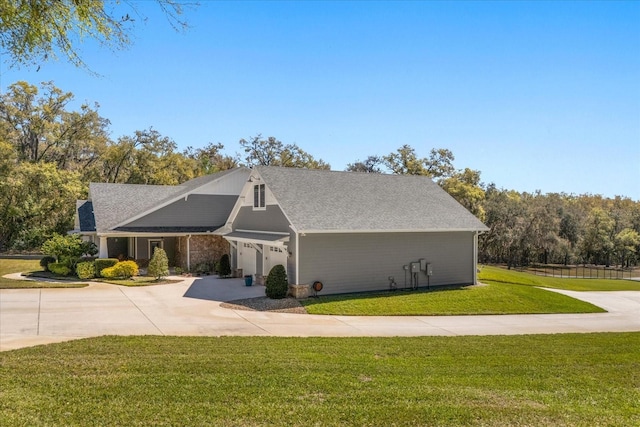 view of front of house featuring driveway, a shingled roof, an attached garage, and a front lawn