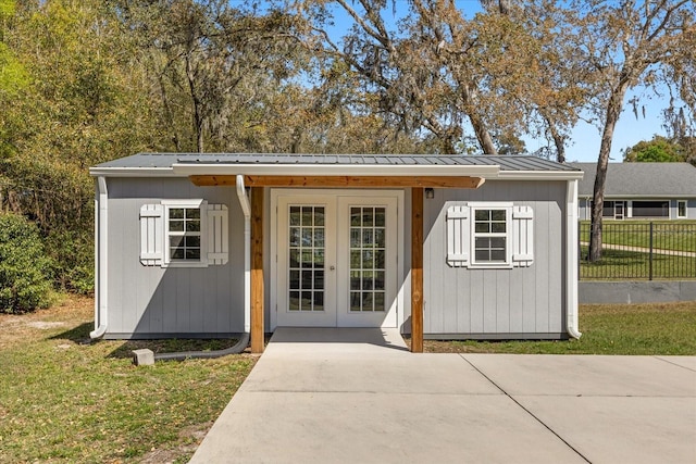 view of outbuilding featuring french doors, an outdoor structure, and fence