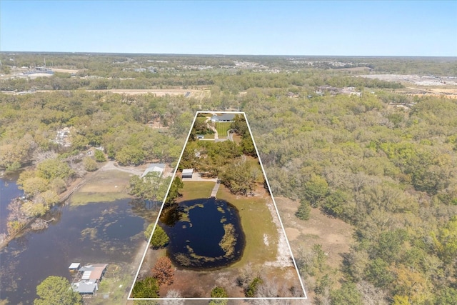 drone / aerial view featuring a water view and a view of trees