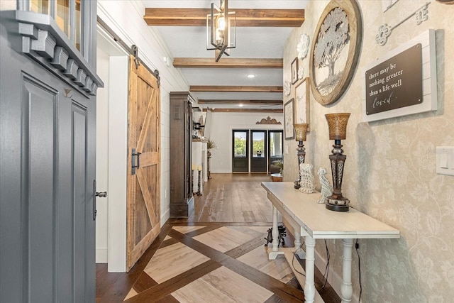 foyer entrance featuring a barn door, wood finished floors, and beamed ceiling