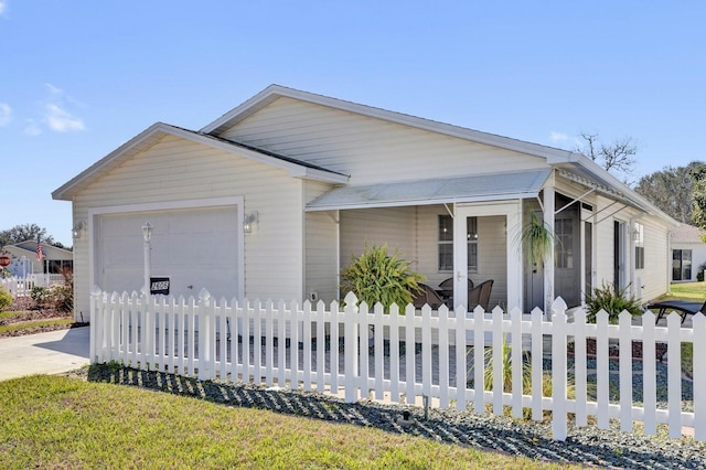 view of front facade featuring a fenced front yard, concrete driveway, and a garage