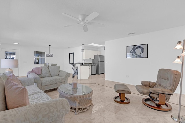 living room with visible vents, light tile patterned floors, a ceiling fan, and baseboards