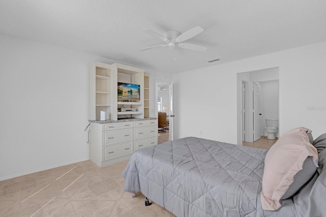 bedroom with light tile patterned floors, visible vents, ensuite bathroom, ceiling fan, and baseboards