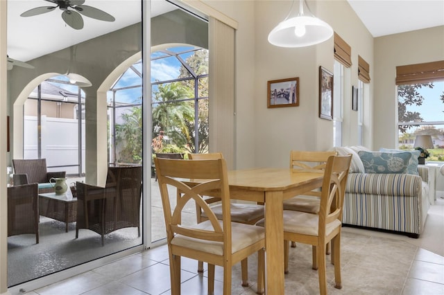 dining space featuring a ceiling fan, a sunroom, and light tile patterned flooring