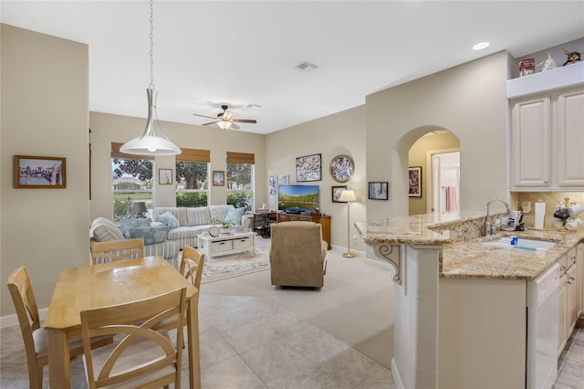 interior space featuring arched walkways, ceiling fan, light tile patterned floors, visible vents, and baseboards