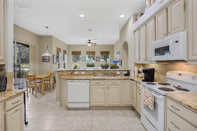 kitchen featuring white appliances, tasteful backsplash, light tile patterned floors, a peninsula, and a sink