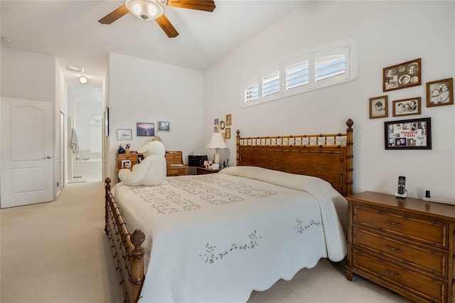 bedroom with ceiling fan, connected bathroom, visible vents, and light colored carpet