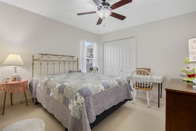 bedroom with a closet, light colored carpet, and baseboards